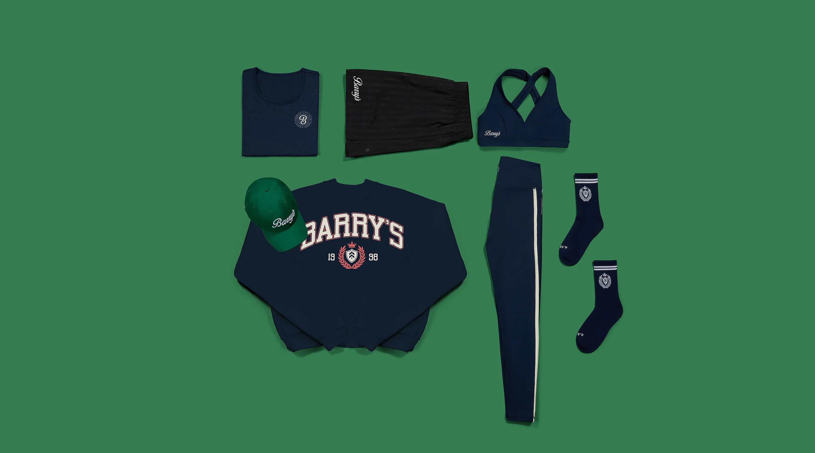 Flat lay of a custom branded apparel collection: sweatshirt, leggings, shorts, bra top, socks and cap